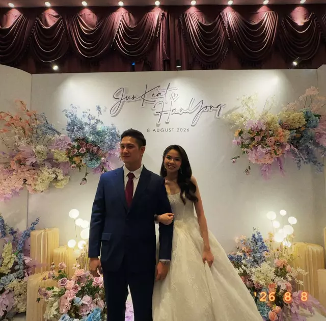 The couple in front of their floral backdrop