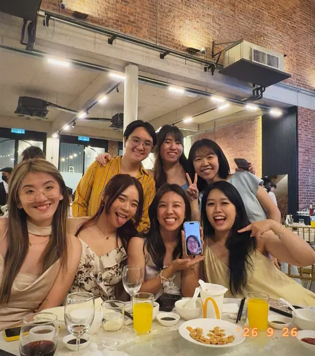 A table of friends posing during dinner