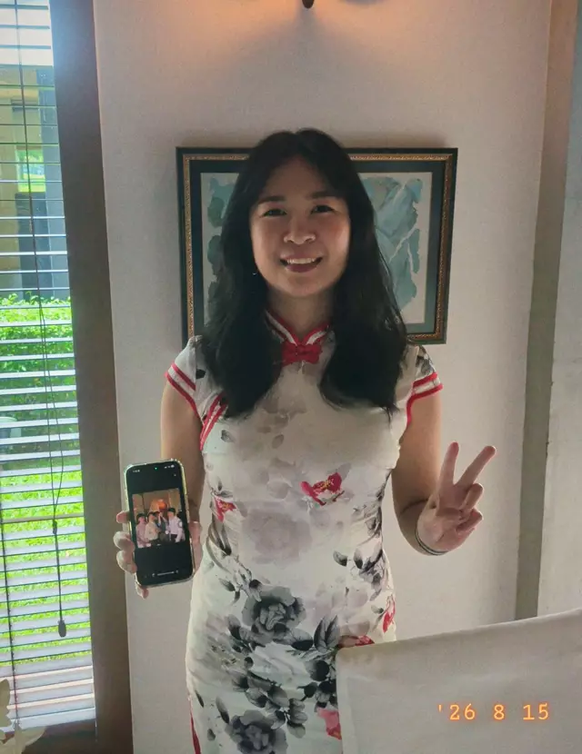 A guest in a cheongsam holding up her phone
